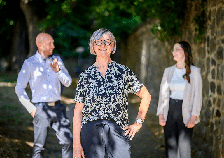 Das Team von Cornelia Rönisch Immobilien vor einer Bruchsteinmauer in Quedlinburg